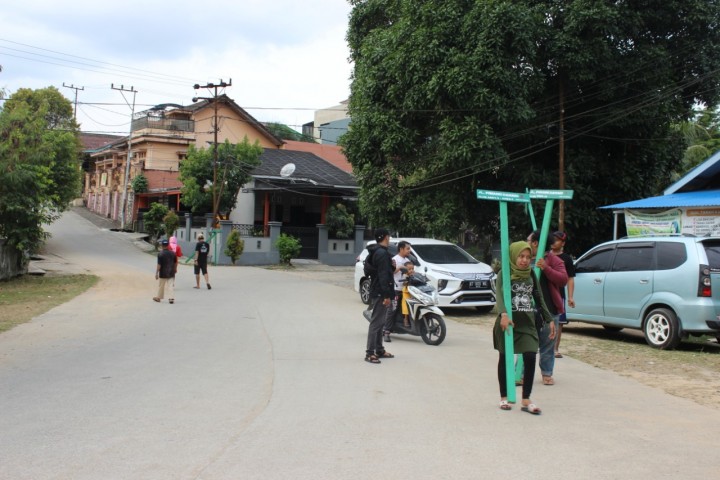 Pemasangan Plang Jalan RT 01 Oleh Mahasiswa KKN 45
