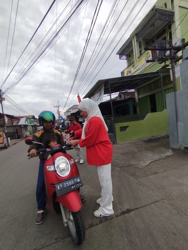 Pembagian bendera kepada warga untuk pengendara roda dua n empat,merayakan Hut RI ke 79
