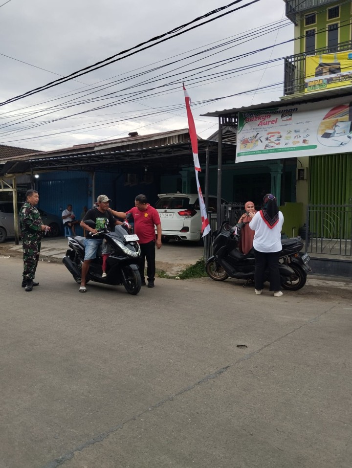 Pembagian bendera kepada warga untuk pengendara roda dua n empat,merayakan Hut RI ke 79