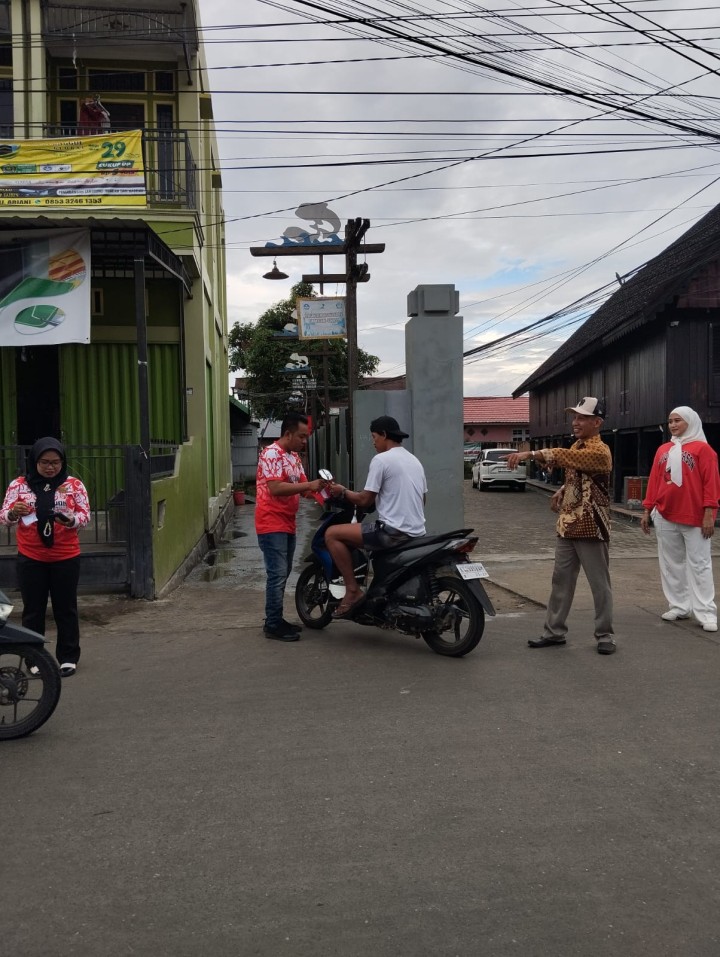 Pembagian bendera kepada warga untuk pengendara roda dua n empat,merayakan Hut RI ke 79
