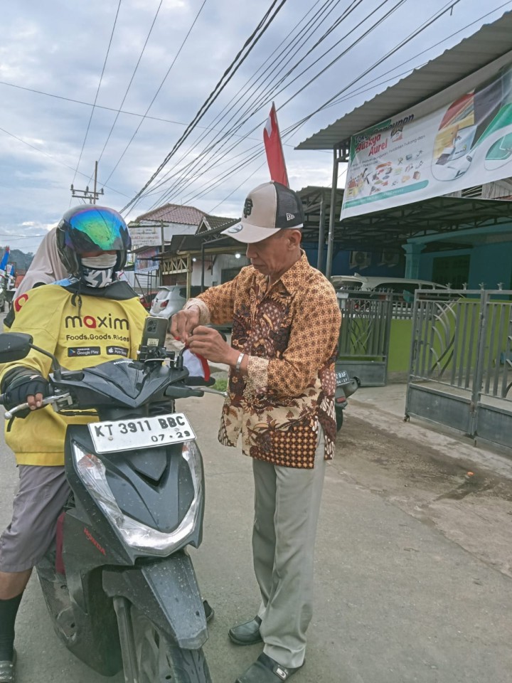 Pembagian bendera kepada warga untuk pengendara roda dua n empat,merayakan Hut RI ke 79