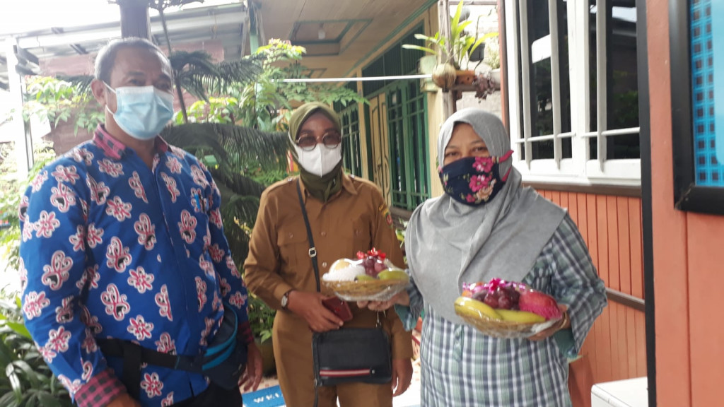 Memberi bantuan kepada warga terkonfirmasi Covid 19