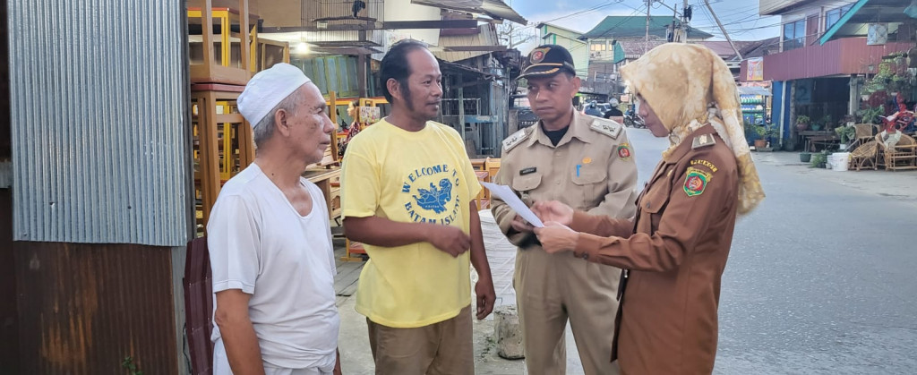 Membagikan Surat Pemberitahuan Pembongkaran Rumah Di Jl. Tarmidi Terkait Normalisasi Sungai Karang Mumus.