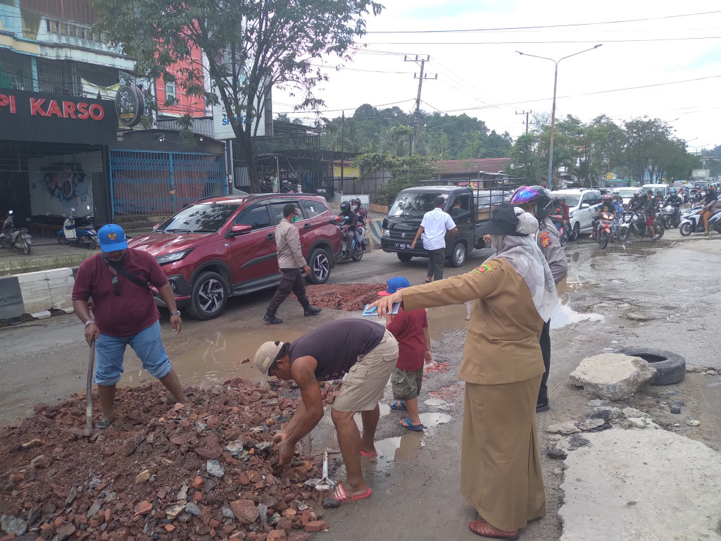 MENUTUP LOBANG YANG ADA DI SEKITAR JALAN DI. PANJAITAN